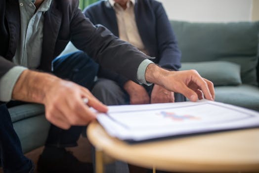 pexels-photo-8439662-8439662 Two men discussing documents during a business meeting, focusing on paperwork.